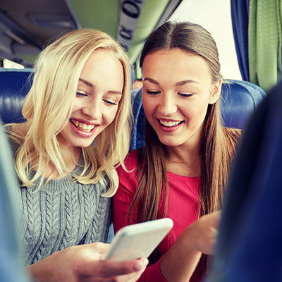 two friends on their pones on a hire bus